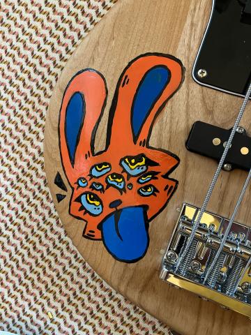 close-up photo of an orange and blue cartoon rabbit head with nine eyes