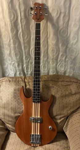 completed bass, on a yellow chair in front of a white curtain