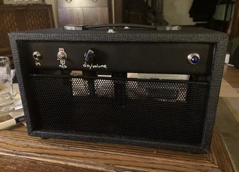 front view of the amp, showing the input jack, a toggle switch, on/volume knob and an indicator lamp