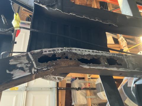 bottom of frame showing plate removed and significant holes in the bottom frame rail