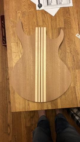 bare guitar-shaped wood slab, with alternating dark and light pieces