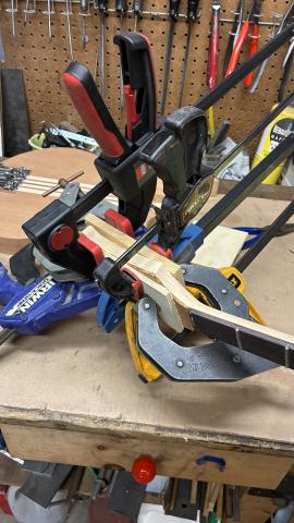 many clamps around the guitar headstock