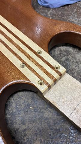 small brass inserts in the body, to support the neck screws