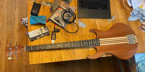 bass on a wooden table with strings installed but no pickup or electronics yet