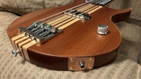 lower 3/4 view of bass body showing bridge, knob, and jack mounting plate
