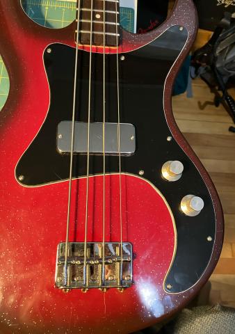 bass body with new pickguard in place, fully assembled with strings and knobs