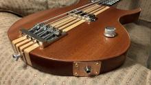 lower 3/4 view of bass body showing bridge, knob, and jack mounting plate